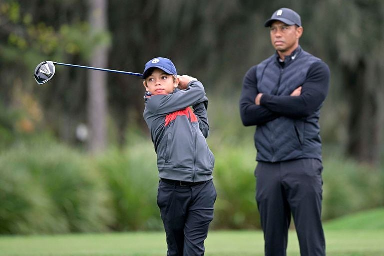 Tiger Woods observa el swing de su hijo Charlie; ambos competirán juntos en el PNC Championship, que se disputará en Orlando y marcará el regreso del ganador de 15 torneos grandes a la actividad tras el accidente de auto sufrido hace 10 meses.