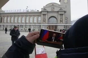 Un hombre ve en su teléfono móvil la declaración de "operación especial" en Ucrania del presidente ruso, Vladimir Putin