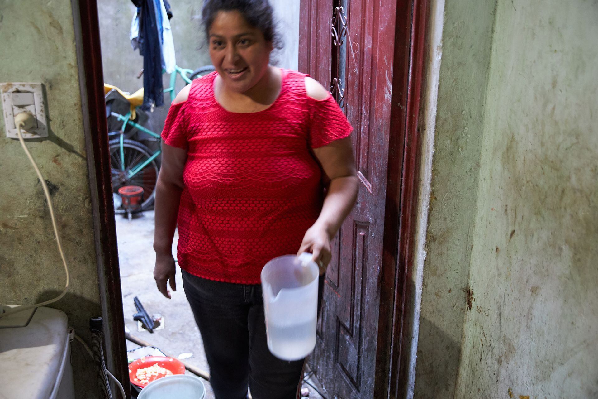 Silvana se vale de una jarra para sacar agua y cocinar