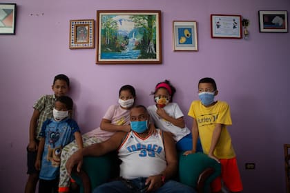 Una familia posa para un retrato en su apartamento del barrio La Lira, de Caracas, durante la pandemia Covid-19. Por @andrernandez