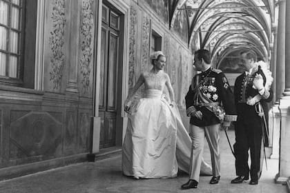 En la iglesia, Grace deslumbró con un traje de novia hecho a la medida de una princesa, confeccionado por treinta modistas, en encaje belga antiguo y bordado con perlas. La falda campana en tafeta de seda tenía tres enaguas bordadas con moños azules.