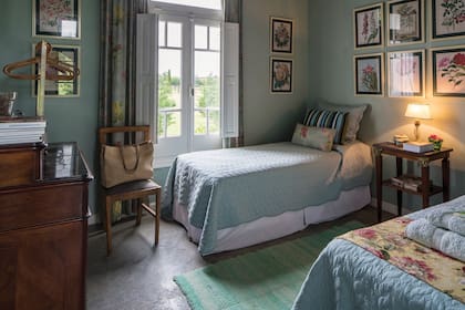 La decoración de uno de los dos cuartos de invitados está dominada por el verde agua. Un perchero de acero que trajo de su boutique en la calle Quintana hace de ropero. Las perchas, de bambú, fueron compradas en Muji y la cómoda, antigua con varios cajones, es de nogal.