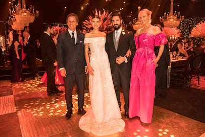 Valeria Mazza (llevó un diseño fucsia de Ménage à Trois) y su marido, Alejandro Gravier, felicitaron a los novios en La Rural.