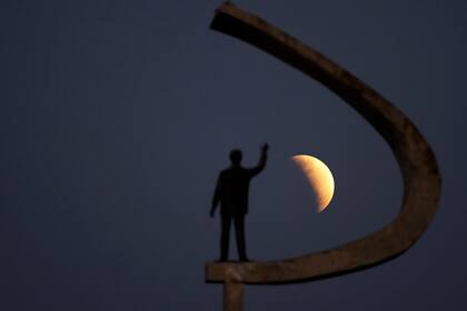 Una estatua del expresidente de Brasil, Juscelino Kubitschek, fundador de Brasilia, se levanta durante un eclipse parcial de luna en los cielos de Brasilia, Brasil