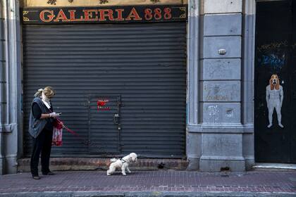 Una mujer pasea a su perro en el barrio de San Telmo en plena cuarentena social y obligatoria en el país. Por @piovanopablo 