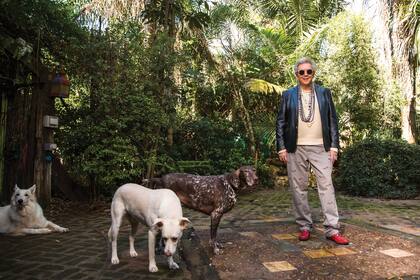 Pepe posa en su enorme jardín junto a tres de sus cuatro perros.