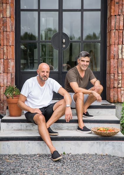 Fabián Zitta junto a su marido, Charly Fonseca posan en las escalinatas de su chacra