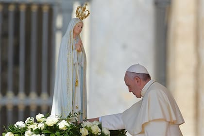El Papa Francisco tocando el manto de la virgen de Fátima en su santuario