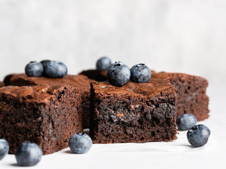 Chocolate,Brownie,Squares,Decorated,With,Fresh,Blueberry,On,Baking,Paper.