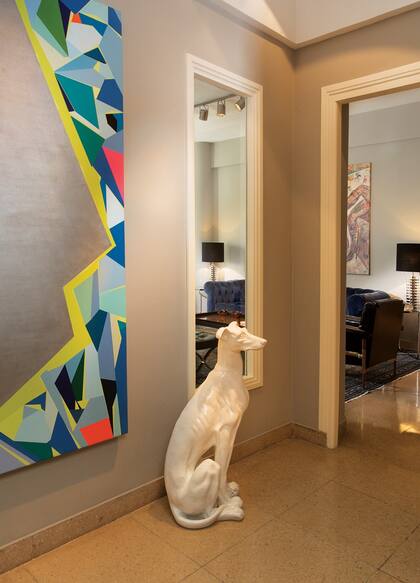 En el hall de entrada hace “guardia” un perro de cerámica comprado en la boutique La Esteña, durante unas vacaciones en José Ignacio. A la izquierda de la imagen, un cuadro de Julio Albisu, que se lo regaló el propio artista tres años atrás.