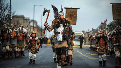 Los participantes vestidos como vikingos marchan por una calle en el anual Up Helly Aa