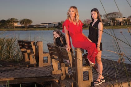 La acompañan sus herederas, Milena y Delfina, en el muelle de su casa con vista a la laguna.