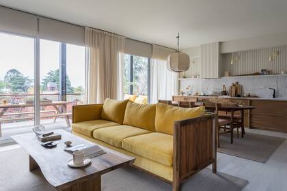 Sofá ‘Toni’ con almohadones en terciopelo, mesa con lonja de tronco, lámpara colgante hecha para Experiencia Casa Living en malla de alambre desplegada sobre papel de algodón (todo de Talleres Sustentables). Cortinas de gasa (Flora E).
