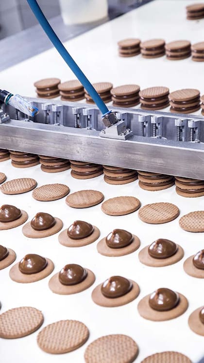 El dulce de leche se compra a un mayorista. Aquí, la última tapita da una vuelta y termina de formar el triple alfajor.
