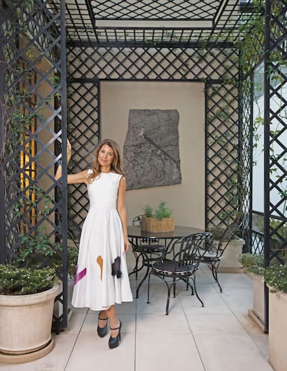 En la terraza, con vestido de cóctel muy femenino de Roksanda. La fotografía estampada en mármol de atrás es de Cata Swinburn. “Ella es un concentrado de talentos, multifacética. ¡Además, es espléndida! Cata decidió el lugar donde instalarla y estamos felices".