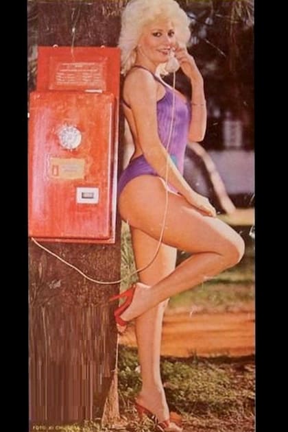 En traje de baño y con un teléfono público, Albinoni recrea el popular personaje que la hizo famosa gracias a la frase “Hola, mami”, en el ciclo televisivo La peluquería de don Mateo.