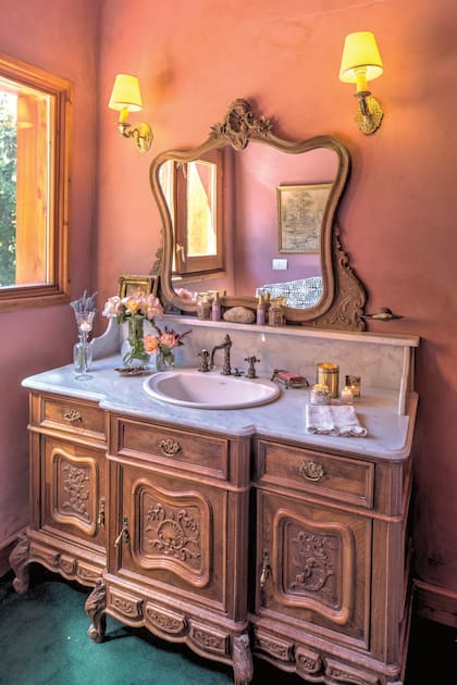 Una vista de uno de los baños de invitados, en el que una antigua cómoda fue convertida en un romántico vanitory
