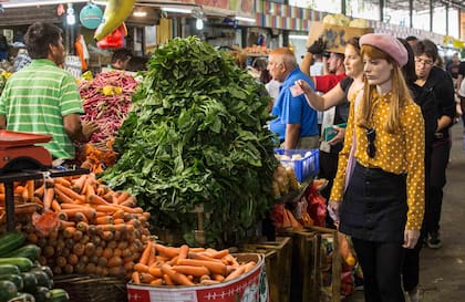 Parvas de porotos frescos, espinacas y zanahorias en un puesto de vegetales del Mercado de la Vega Central.