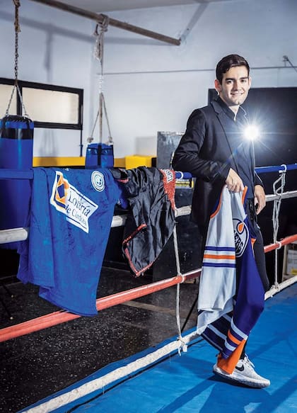 Ramiro posa con algunas de las prendas que heredó de su padre: la camiseta de Belgrano de Córdoba, club del que era fanático, firmada por todos los jugadores, el short de boxeador que usó en su maratón de conciertos en el Luna Park y una remera de hockey sobre hielo a la que le tenía gran aprecio.