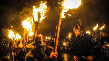 Los participantes vestidos como vikingos marchan en la procesión antes de quemar su nave en la culminación del festival Up Helly Aa
