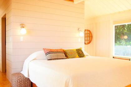 Luminoso y revestido en madera, el dormitorio tiene un estilo minimalista y vistas al mar turquesa