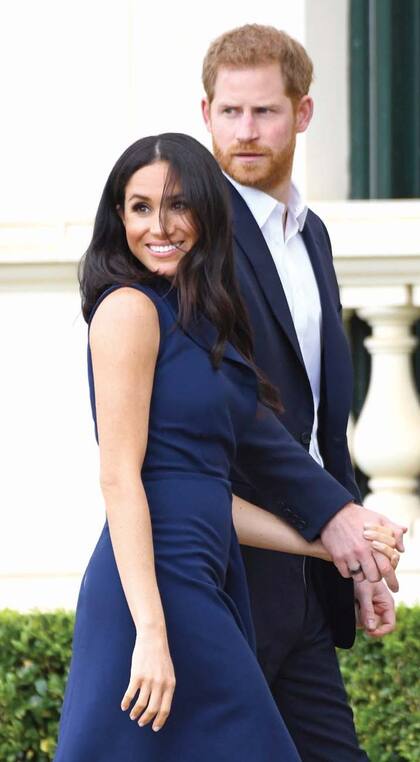 Para la visita a la Casa del Gobernador, en Melbourne, Meghan optó por un diseño azul marino de Dion Lee con el que mostró su incipiente pancita. Allí quedó a la vista el anillo negro que Harry lleva en su mano derecha. Es una pieza que monitorea la actividad durante el día y las horas de sueño.