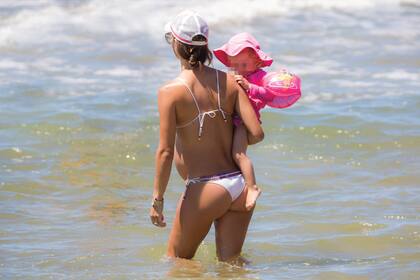 Paz, que está espléndida en su octavo mes de embarazo, lleva al agua a Luz, su hija mujer. Diego y Paz se casaron en 2013, un año después de conocerse en un asado. Ella jugaba al hockey en la 1° división de Old Girls, e integró el seleccionado uruguayo de hockey sobre césped.