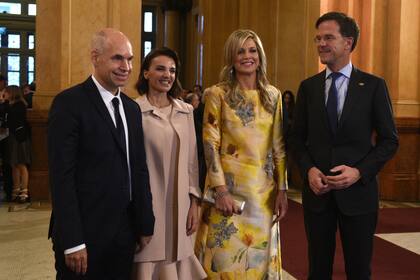 Máxima de Holanda fue de las primeras en llegar. Impactó con un vestido de seda dorado con flores estampadas y el pelo suelto y con ondas.