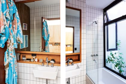 Los detalles en madera le dan carácter al baño, al igual que los azulejos tipo subway, pero orientados verticalmente y con juntas gruesas de pastina negra.