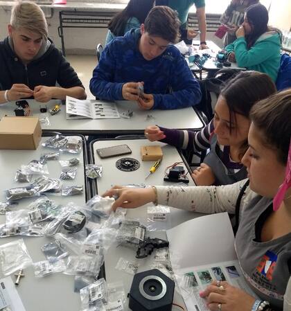 Alumnas y alumnos de nivel básico armando piezas de un kit de robótica que recibió la escuela por parte del INET