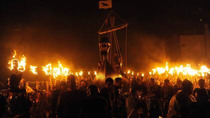 Los participantes vestidos como vikingos marchan en la procesión antes de quemar su nave en la culminación del festival Up Helly Aa