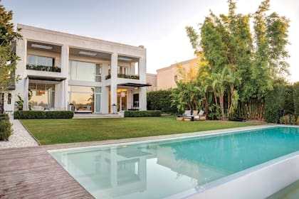 Una vista imponente de la casa desde el jardín en el que armaron, además, un living sobre el pasto (Negro House Pleasures).