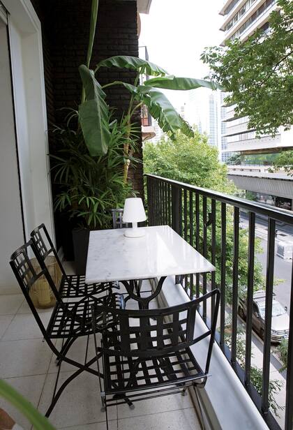 El balcón, con muebles de hierro y mármol