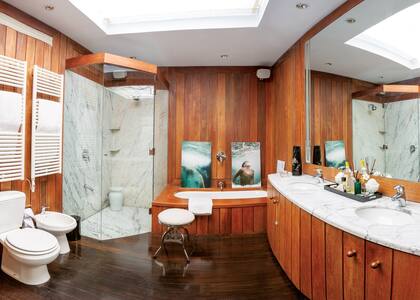 Hecho en lapacho, el baño es una oda a la sencillez. Sobre la bañadera, una serie de fotos de los hijos de la dueña de casa debajo del agua; las imágenes son obra del fotógrafo Daniel Balda.