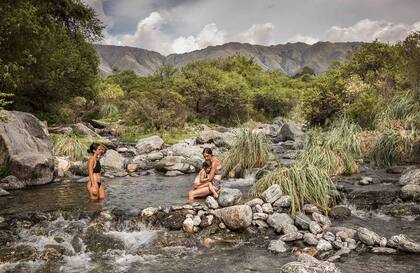 Niña, madre y una amiga en las aguas transparentes de la reserva Los Barrancos, en Luyaba.
