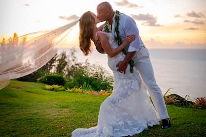 Los flamantes novios sellaron su amor con un beso apasionado mientras se ponía el sol en el atardecer.