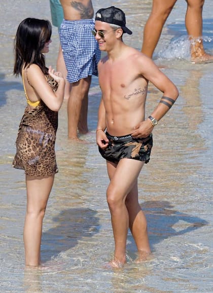 Con gafas de sol y una gorra Goorin Bros –la misma marca que usa Lio Messi–, “La Joya” Dybala se protege del sol tras abandonan las reposeras y caminar por la playa.
