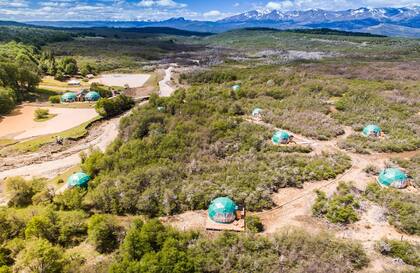 Vista aérea de los Domos rodeados de verde y con las montañas de fondo.