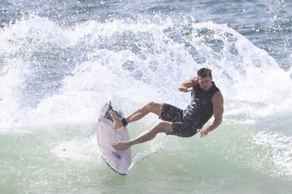 Chris, ya relajado, remontando las olas con su tabla