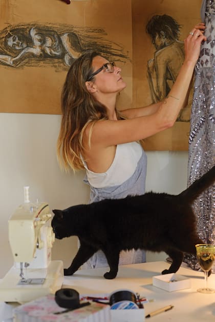 Hilo y aguja al momento de la creación de sus vestidos, con uno de sus gatos. Tiene dos: Yoda y China.