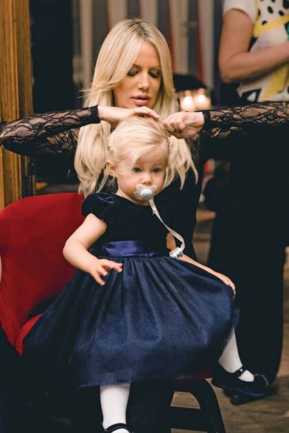Siempre atenta a su hija, Luciana acomoda el peinado de Matu. Para la ocasión, la niña lució un vestido azul marino de Ralph Lauren que combinó con zapatos de mini Azurra. 