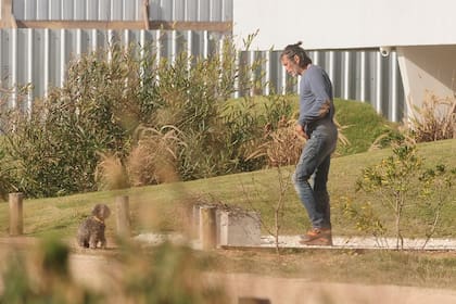 Nicolás acompaña a su caniche Allegra en su paseo de la mañana por el frente de la casa