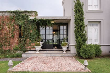 En la entrada conviven en armonía los distintos lenguajes y estilos que le dan forma a la casa. A la izquierda, el “bloque social” está dominado por una arquitectura moderna y, a la derecha, el bloque de los dormitorios, de marcada impronta francesa
