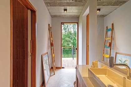 Como los dormitorios comparten el mismo baño, el sector de las bachas se dejó abierto en el pasillo, con un tratamiento material coincidente con el resto y a su altura estética.