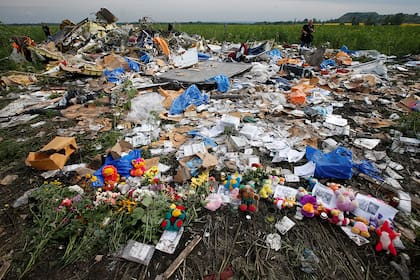 Cerca del asentamiento de Rozspyne en la región de Donetsk se ven flores y recuerdos dejados por residentes locales