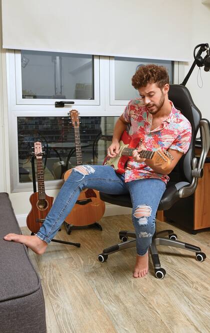 Ruggero posa en el estudio de música que armó en el departamento. Allí convive con sus guitarras: las eléctricas llevan nombre de varón (la que está tocando es una Fender Stratocaster, modelo Mark Knopfler, a la que llamó “Rocky”); y las acústicas, nombres de mujer: Roma y Lucía.