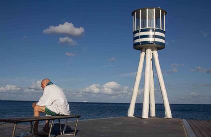 Luego de nadar, y secarse, las personas se quedan unos minutos sentados a disfrutar del sol.