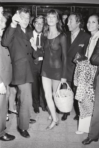 Sensual, con un vestido transparente de red y su canasto infaltable, en la premiére en Francia de Slogan, la película de Pierre Grimblat en la que se enamoró de Serge Gainsbourg. Con ella en la foto el propio Serge y Grimblat.
