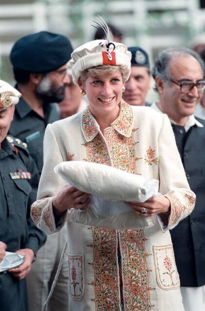 Diana en 1996, con sombrero y abrigo muy similares, recibe un regalo apenas pisa la región.