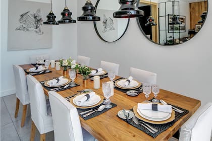 Una mesa impecable, iluminada por cuatro lámparas de vidrio de Negro House Pleasures, con platos que María trajo de un viaje y copas de cristal de Bohemia, regalo de su casamiento. Sobre la pared, dos espejos de hierro. En uno de ellos asoma un cuadro de la artista plástica Catalina Scoppa.